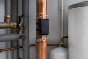 Boîtier anti-calcaire électronique type Dropson EMI 2500 installé sur une canalisation d'eau domestique